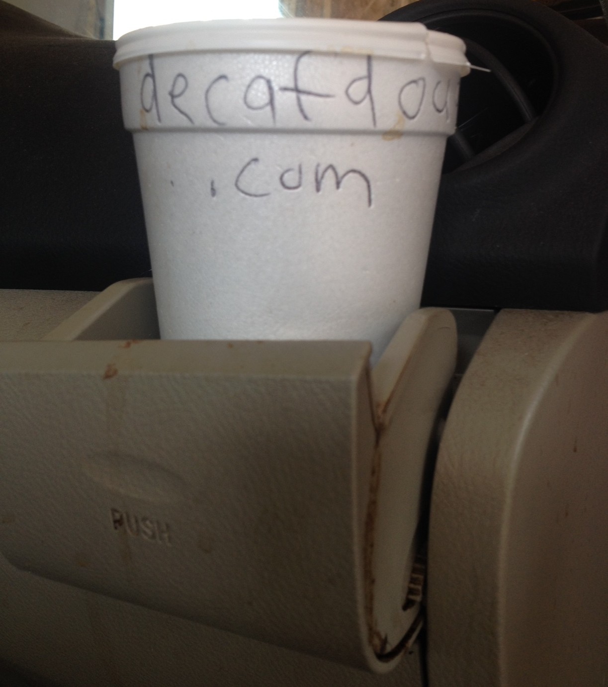 Photo showing an official Decaf Doug styrofoam cup in a car's cup-holder